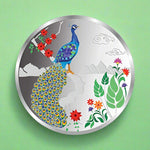 Load image into Gallery viewer, A silver coin with a colorful peacock design surrounded by floral elements on a white background.