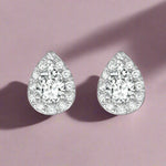 Load image into Gallery viewer, A pair of sterling silver earrings with a central pear-shaped stone surrounded by clear cubic zirconia accents.