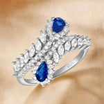 Load image into Gallery viewer, A sterling silver ring with a band, featuring a blue sapphire and clear cubic zirconia stones set in a traditional claw setting.