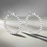 Load image into Gallery viewer, A pair of 925 sterling silver hoop earrings with a two-tone design, featuring a series of small balls attached to the hoop.