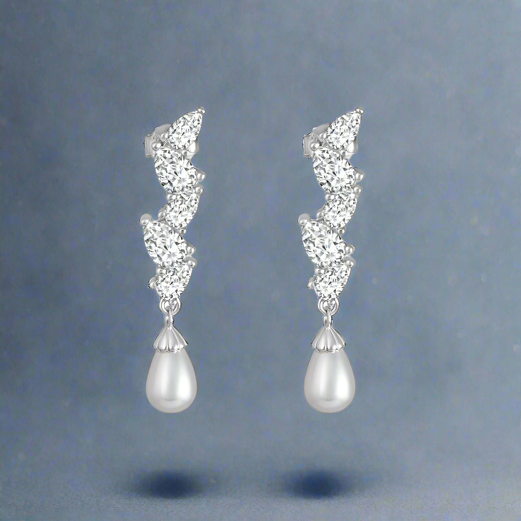 A pair of silver earrings studded with cubic zirconia and pearl accents, set in a classic hoop design.