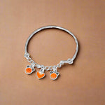 Load image into Gallery viewer, A silver bracelet with three orange and white bead charms, designed for children.