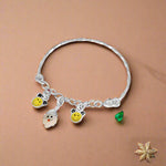 Load image into Gallery viewer, A silver bracelet with charms shaped like smiling faces and small yellow beads, designed for children.