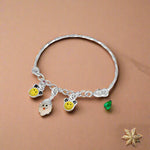 Load image into Gallery viewer, A silver bracelet with charms shaped like smiling faces and small yellow beads, designed for children.