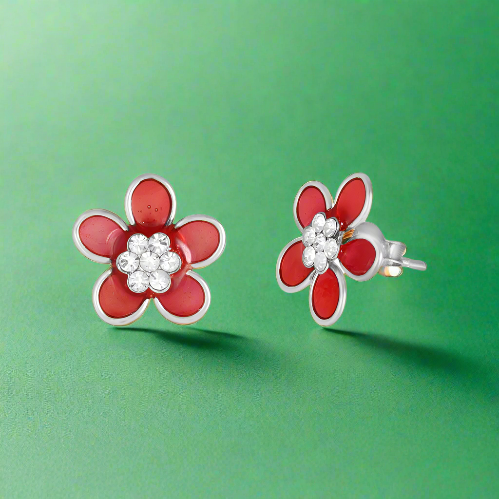 A pair of red stud earrings with sparkling gems set in silver, on a white background.