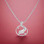 Load image into Gallery viewer, A silver pendant featuring a crescent moon design with cubic zirconia embellishments, attached to a chain.