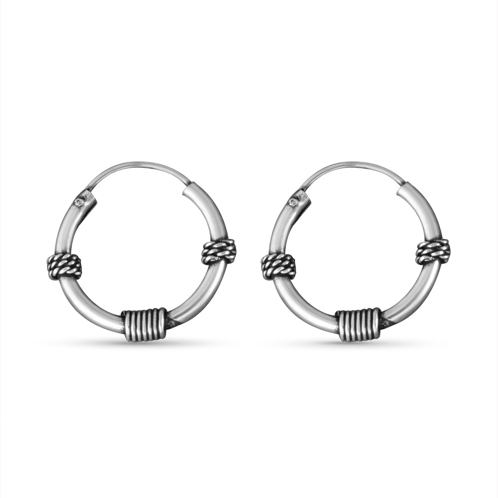 Pair of silver hoop earrings with woven design on a white background