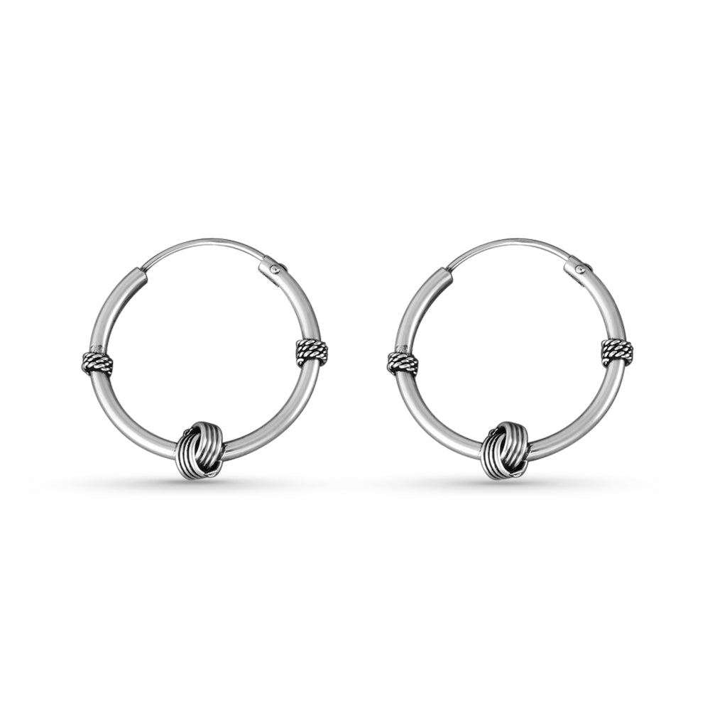 Pair of silver hoop earrings on a white background