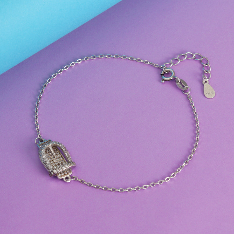 Silver bracelet with a decorative clasp on a purple and blue background