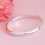 Load image into Gallery viewer, Silver bangle on a pink background with a pink flower
