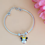 Load image into Gallery viewer, Silver bracelet with a cartoon character charm on a beige background with pink flowers.
