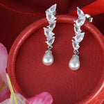 Load image into Gallery viewer, Pearl and gemstone earrings on a red fabric background
