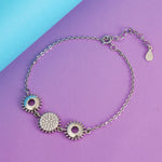 Load image into Gallery viewer, Silver bracelet with circular charms on a purple and blue background
