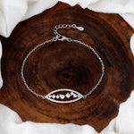 Load image into Gallery viewer, Silver bracelet with a decorative clasp on a wooden surface
