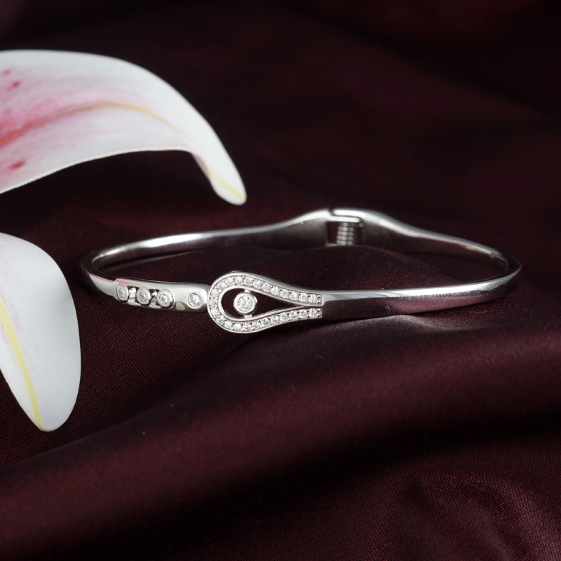 Silver bracelet with decorative elements on a dark fabric background