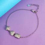 Load image into Gallery viewer, Silver bracelet with heart-shaped charms on a purple and blue background
