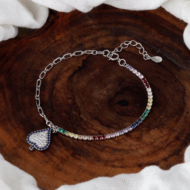 Multicolored beaded bracelet with a heart charm on a wooden surface