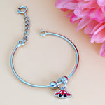 Load image into Gallery viewer, Silver bracelet with a red and blue charm on a pink background
