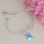 Load image into Gallery viewer, Silver bracelet with a small charm on a beige background with pink flowers
