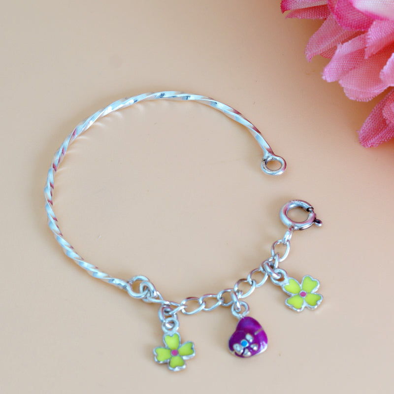 Silver bracelet with colorful charms on a pink floral background