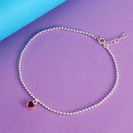 Load image into Gallery viewer, Silver beaded anklet with a red heart charm on a purple and blue background
