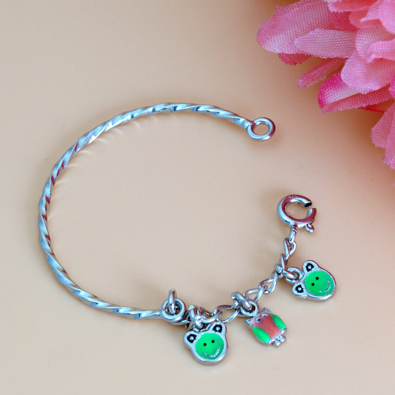 Silver bracelet with frog-themed charms on a beige background