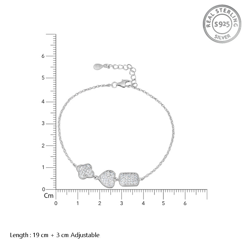 Silver bracelet with three heart-shaped charms on a white background with measurement scale.