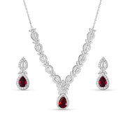 A sterling silver jewelry set including a necklace, bracelet, earrings, and ring, adorned with red and clear colored stones.
