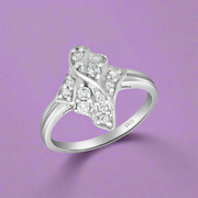 A sterling silver ring with multiple sparkling stones set in a flower-like shape on a white band.