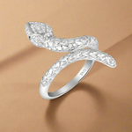 Load image into Gallery viewer, A sterling silver ring with a serpent or snake-like design, adorned with cubic zirconia stones set in a ring setting.
