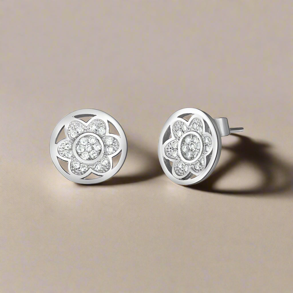 A pair of 925 sterling silver stud earrings with a floral design, adorned with cubic zircons.