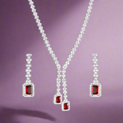 A set of 925 sterling silver jewelry including a necklace, bracelet, earrings, and ring, studded with cubic zirconsia, featuring red and clear colored stones.
