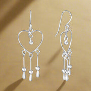 A pair of 925 sterling silver earrings featuring a heart shape with dangling circular details.