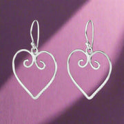 A pair of sterling silver hoop earrings designed in the shape of hearts with intricate details, displayed against a white background.