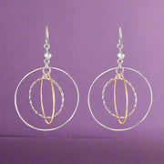A pair of Galaxy Two Tone Link 925 Sterling Silver Earrings, featuring large silver hoops with gold accents, dangle from fish hook closures.