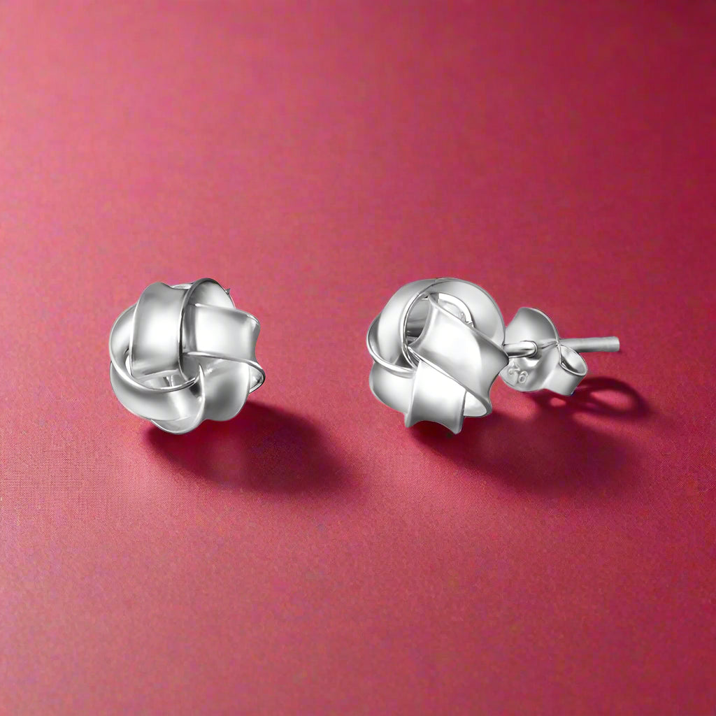 A pair of sterling silver stud earrings with a curly round shape.