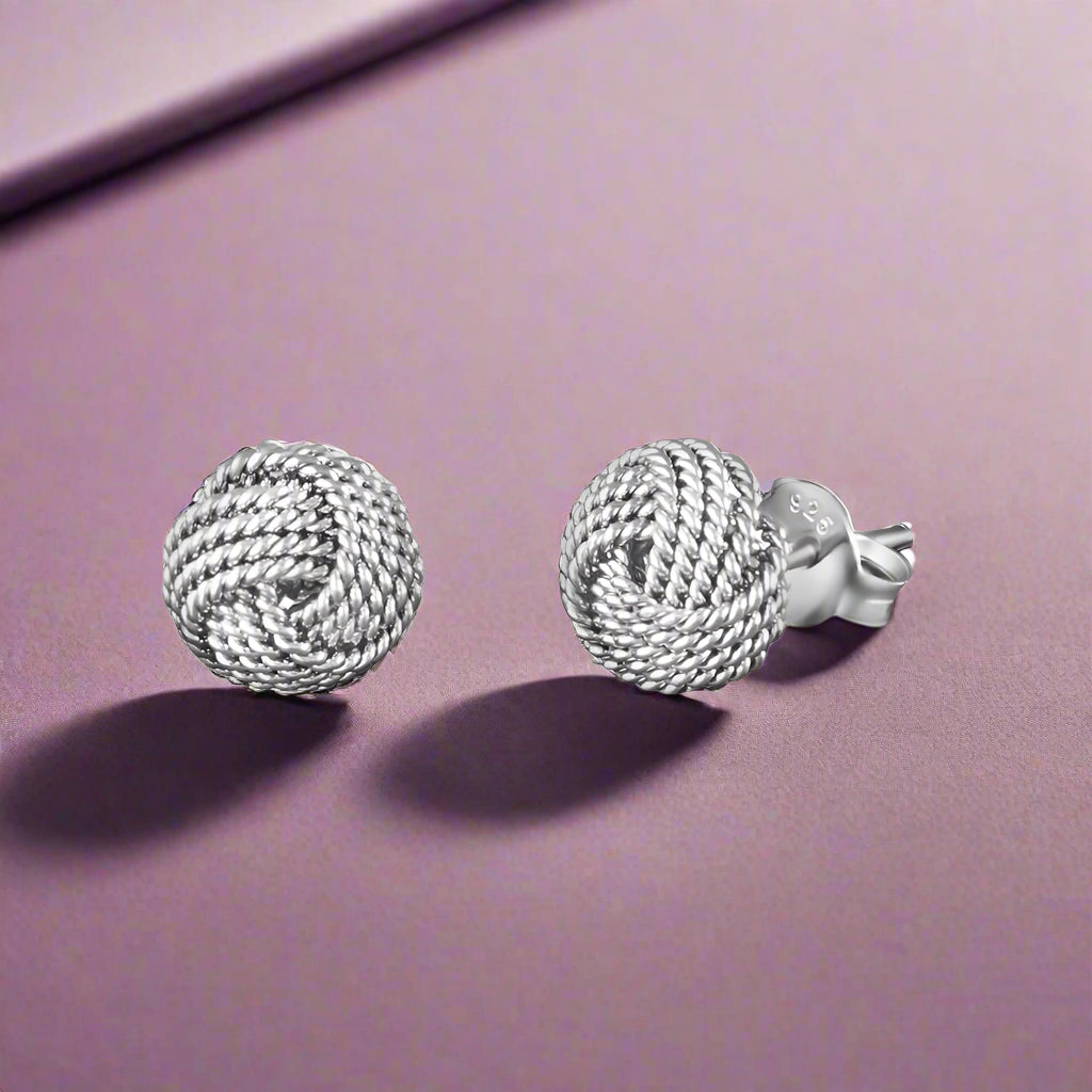 A pair of silver stud earrings designed in a rope-style knot pattern.