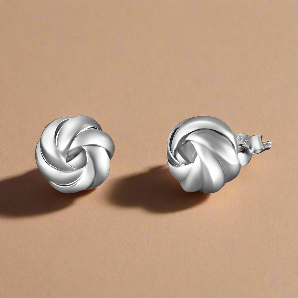 A pair of 925 sterling silver stud earrings with a round flowery shape design.
