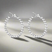 A pair of 925 sterling silver hoop earrings with a two-tone design, featuring a series of small balls attached to the hoop.