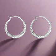 A pair of sterling silver hoop earrings with a twisted hoop design, displayed against a white background.