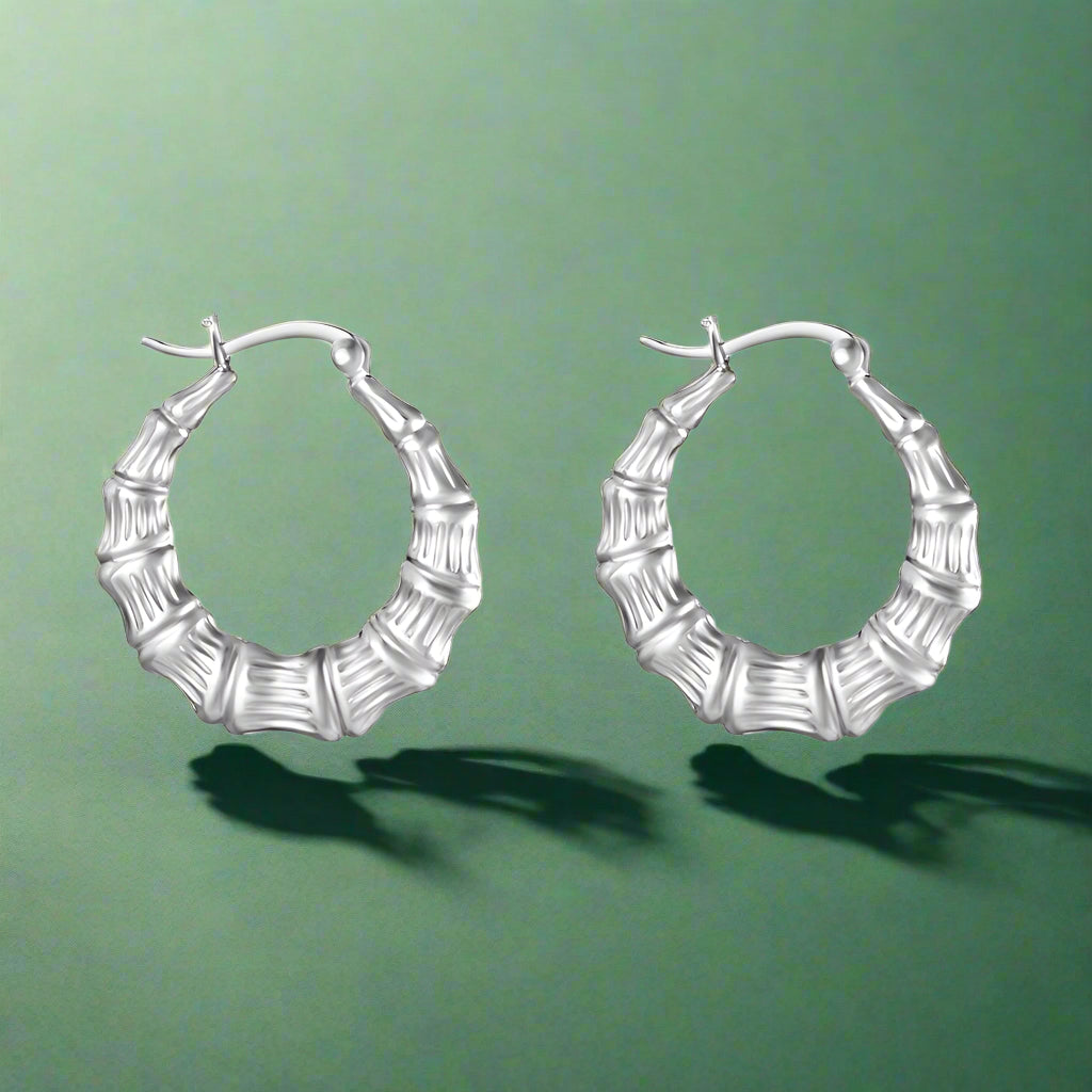 A pair of sterling silver hoop earrings with a bamboo-inspired design, featuring a two-tone finish.