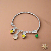 A silver bracelet with charms shaped like smiling faces and small yellow beads, designed for children.