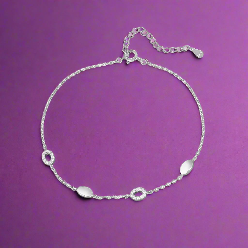 Silver anklet with small round pendants on a white background