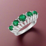 Load image into Gallery viewer, A sterling silver ring featuring a cluster of green cubic zirconia stones set in a traditional solitaire design.
