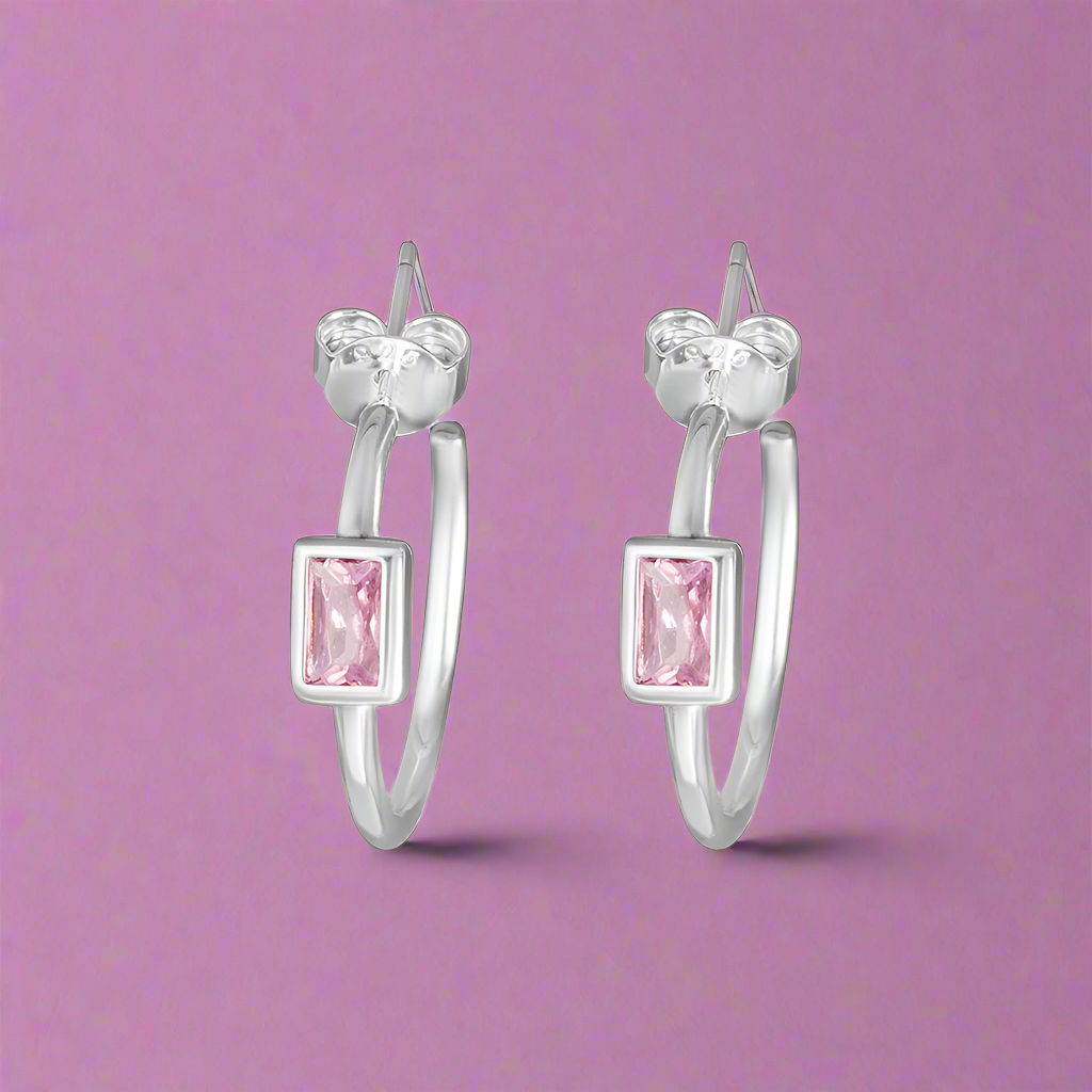 A pair of silver hoop earrings with a pink and clear color scheme.