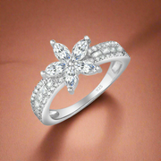 A sterling silver ring with a flower-shaped central mount surrounded by a band with sparkling zirconia stones.