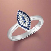 A sterling silver ring with a blue cubic zirconia center stone, surrounded by smaller blue cubic zirconia pieces set in a silver band.