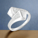 Load image into Gallery viewer, A white gold sterling silver ring with a clear, sparkling centerpiece surrounded by smaller clear cubic zirconia stones set in a classic six-prong setting.
