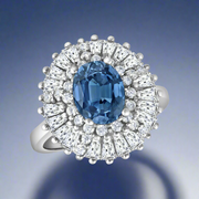 A sterling silver ring with a large blue central cubic zirconia surrounded by a halo of smaller clear cubic zirconias.