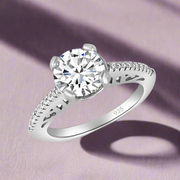 A 925 sterling silver solitaire ring with a large central cubic zirconia and smaller stones on the band, set against a white background.